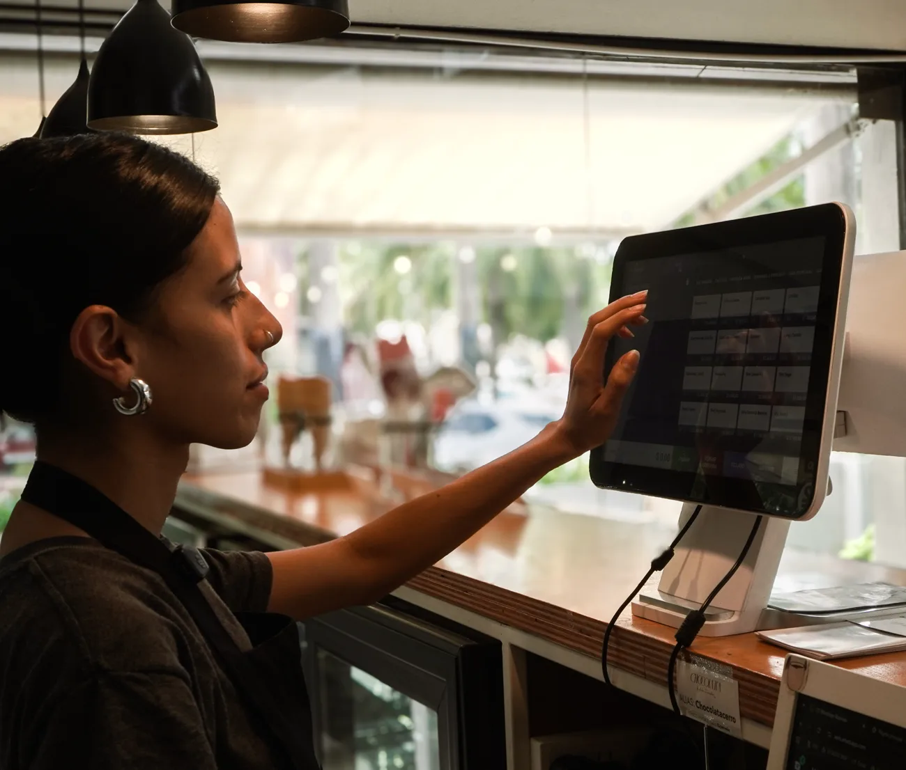 Cajera usando el punto de venta Bistrosoft de doble pantalla en una cafetería